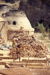 Image du Maroc Professionnelle de  Les ouvriers s’activent près des fours où l’on procède à la cuisson des poteries en céramique dans la Vallée Chaâba à Safi, Samedi 30 Août 1997. (Photo / Abdeljalil Bounhar)